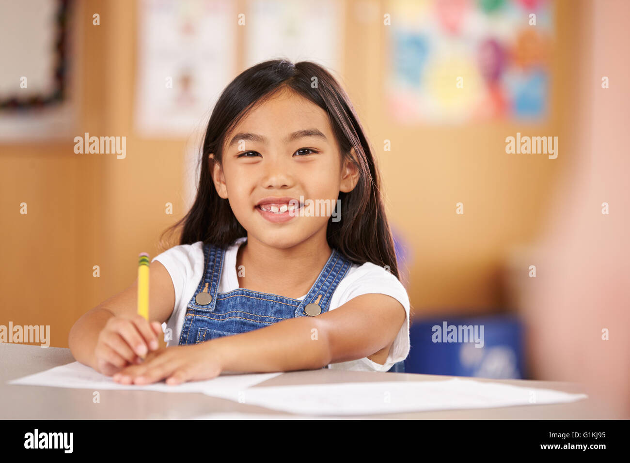 Portrait d'une fille à l'école élémentaire sitting in classroom Banque D'Images