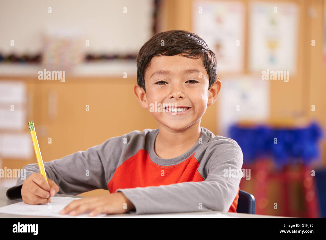 Portrait d'un garçon à l'école primaire sitting in classroom Banque D'Images