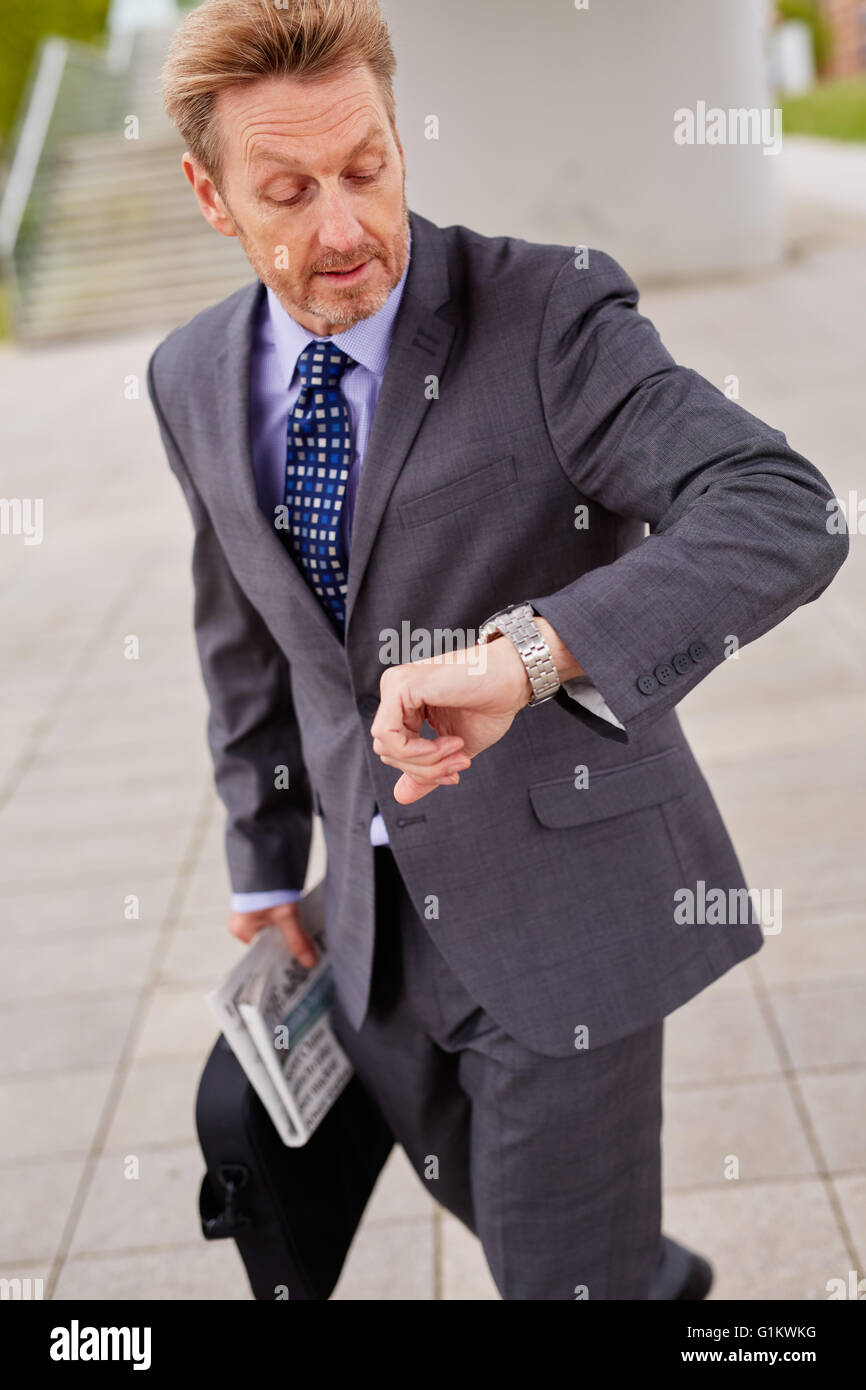 L'homme regardant sa montre se précipiter au travail Banque D'Images