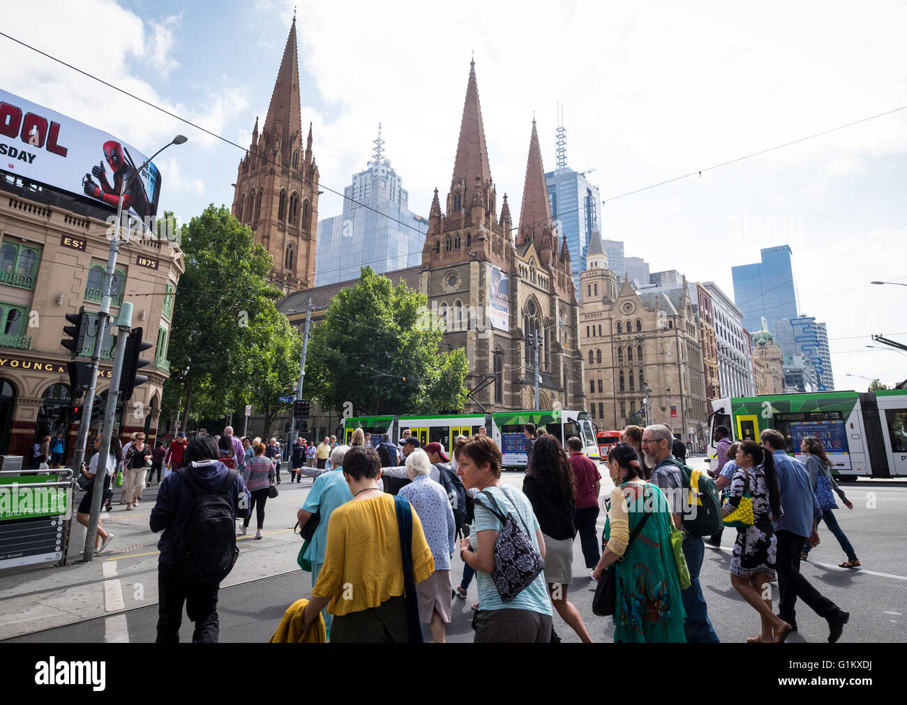 Les personnes qui traversent la rue Flinders près de la Cathédrale St Paul à Melbourne, Australie Banque D'Images