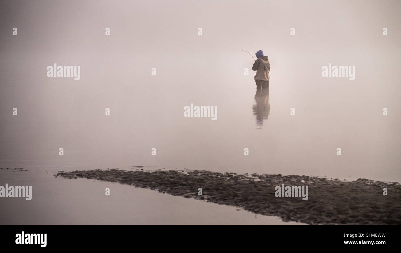 Pêcheur debout dans le fleuve Fraser à Poplar Bar à Glen Valley en Colombie-Britannique, Canada, le brouillard d'un matin d'octobre Banque D'Images