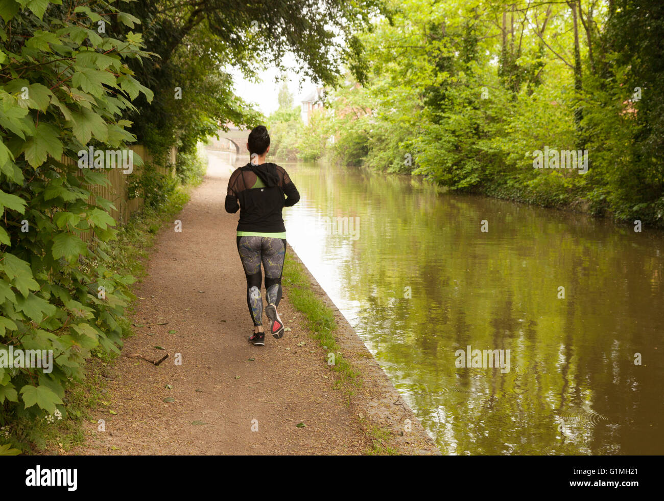 Woman running jogging le long du chemin de halage, Grand Union Canal à Warwick, Warwickshire, Angleterre, Royaume-Uni Banque D'Images