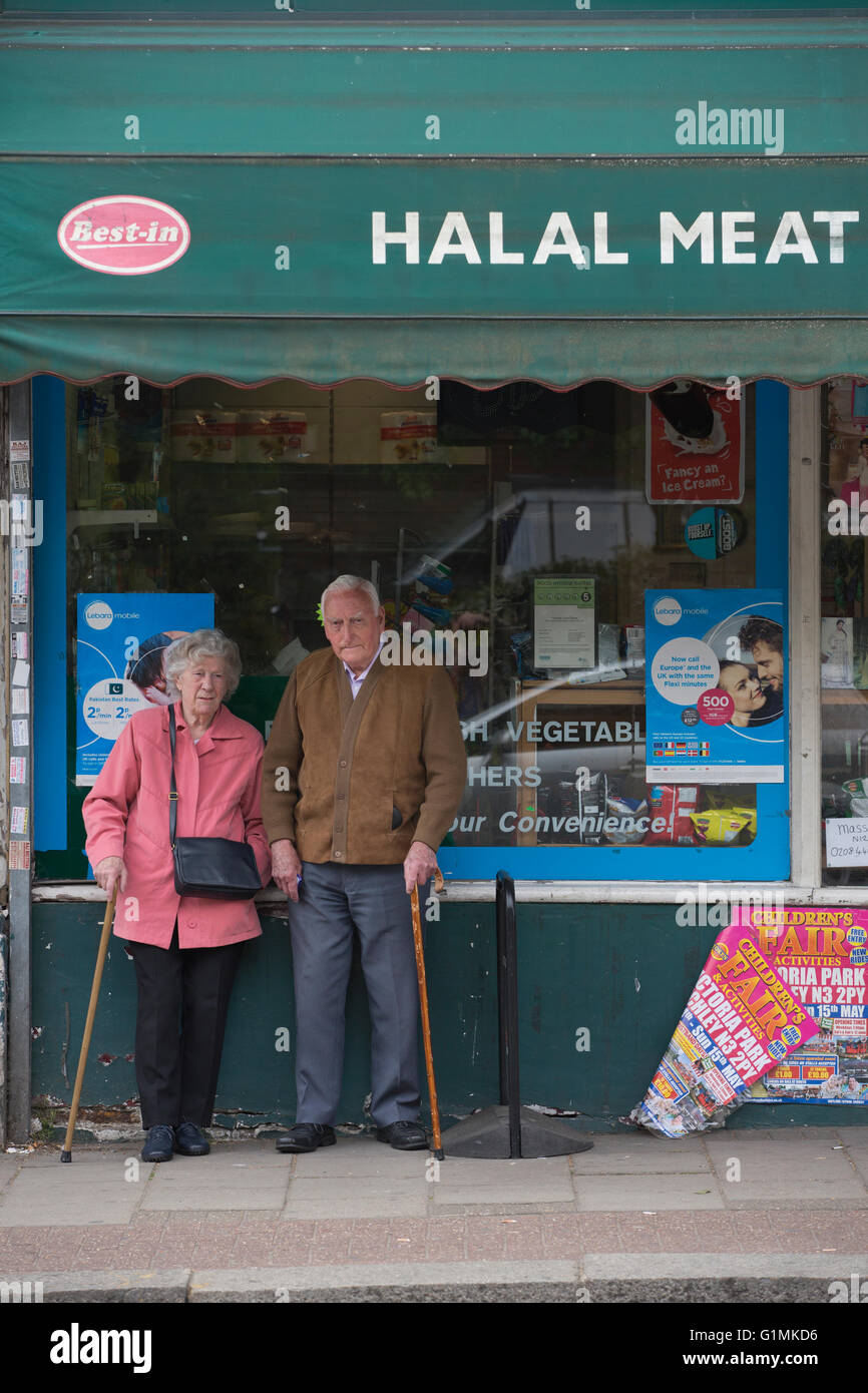 Un couple de personnes âgées s'est tenu en dehors de la viande et de la volaille halal butchers shop, Finchley Central, au nord de Londres, Angleterre, RU Banque D'Images