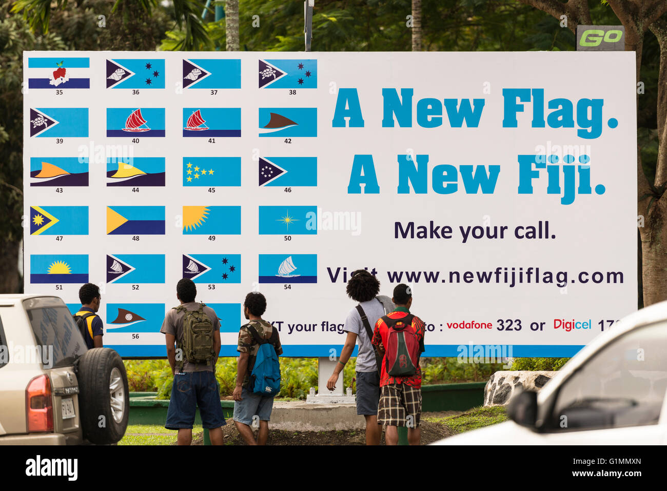 Les jeunes hommes, l'air dans un éventaire routier à Suva affiche montrant différents modèles pour un nouveau drapeau national pour les Fidji. Les plans basés sur une pirogue traditionnelle. Banque D'Images