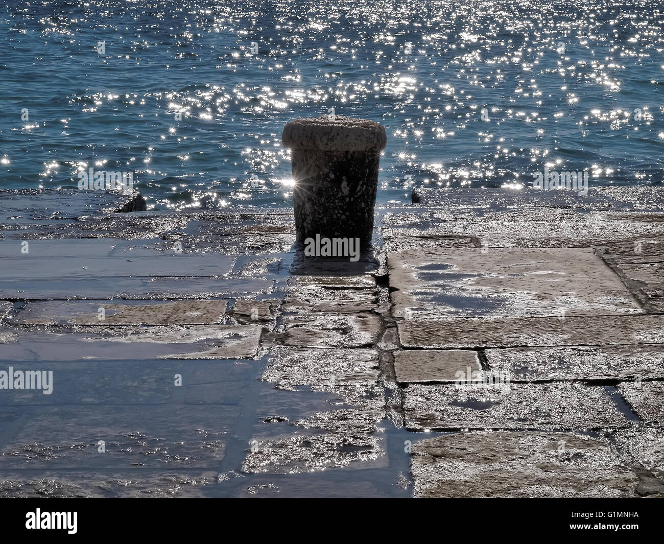 Ancienne borne d'amarrage contre la mer Banque D'Images