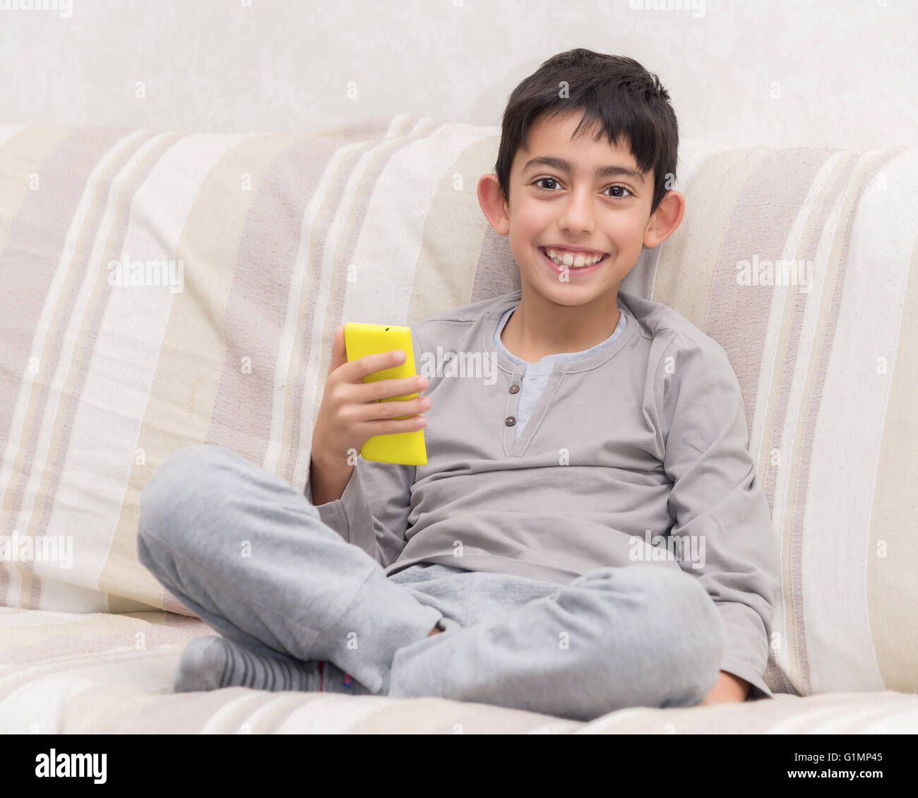 Smiling Young boy with smart phone Banque D'Images