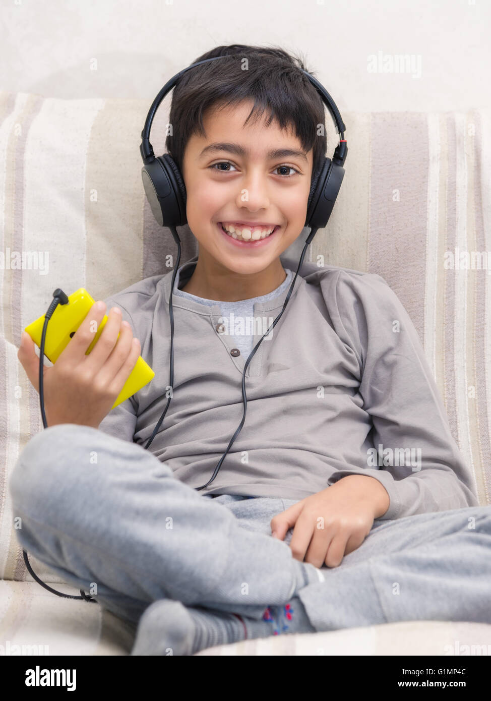 Jeune garçon à l'écoute de la musique avec smart phone et casque Banque D'Images