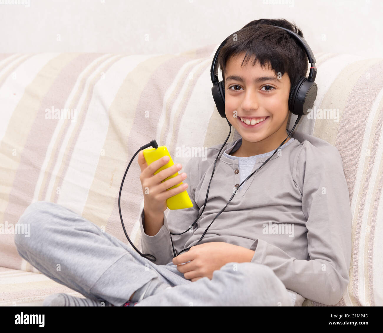 Jeune garçon à l'écoute de la musique avec smart phone et casque Banque D'Images