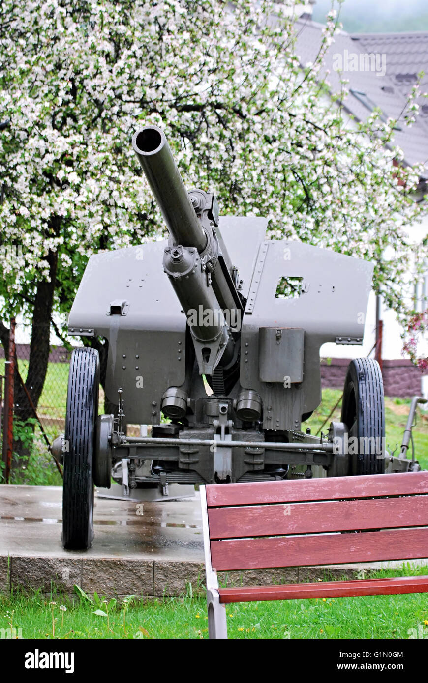 Cannon à partir de la Seconde Guerre mondiale avec l'arbre en fleurs et banc à Zliechov village de Slovaquie Banque D'Images