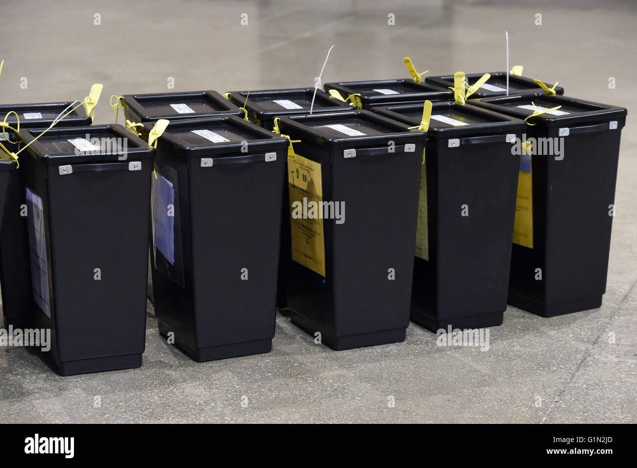 Nombre d'élection, les urnes, noir avec du jaune tags non ouvert,dans une ligne sur le terrain, à partir du haut, assise sur une table Banque D'Images