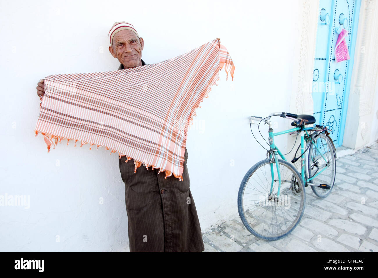 KAIROUAN, TUNISIE - 16 septembre 2012 : Un vieil homme musulman foulards vente dans la rue de Kairouan, Tunisie. Banque D'Images