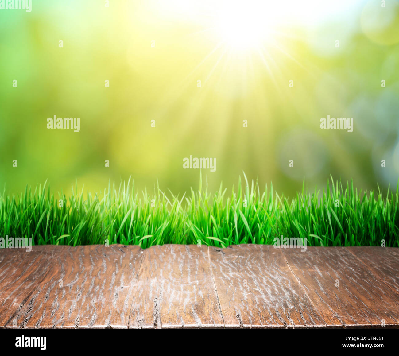 Vieux plancher en bois marron avec de l'herbe verte sur le bord. Arrière-plan de la nature. Banque D'Images