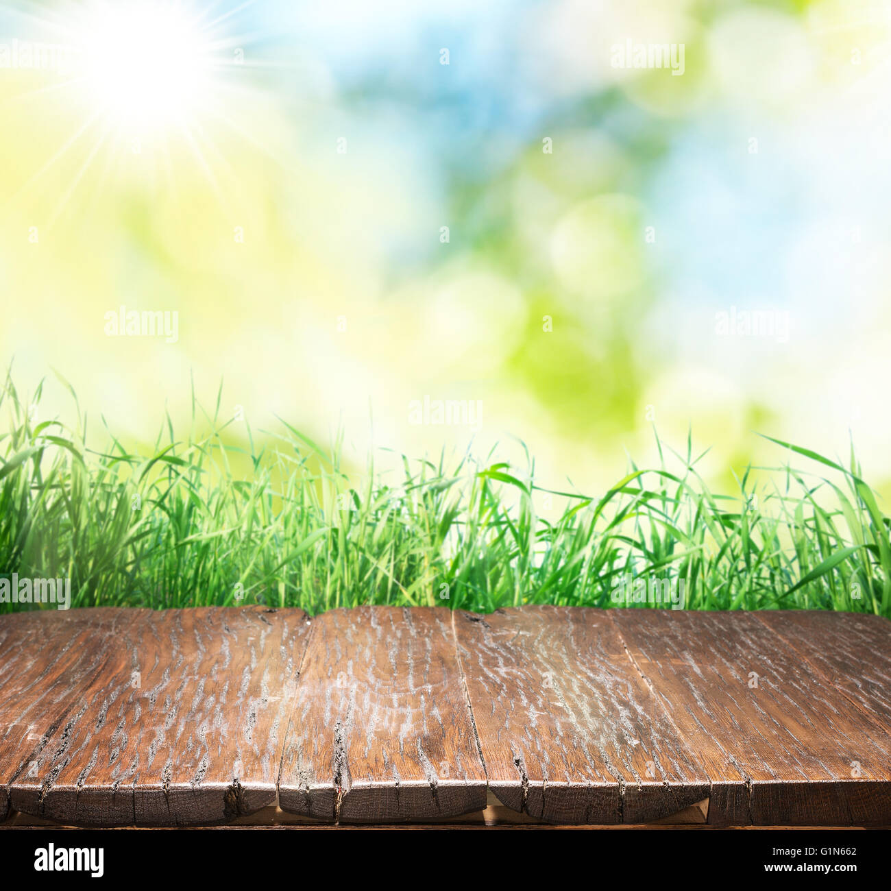 Vieux plancher en bois marron avec de l'herbe verte sur le bord. Arrière-plan de la nature. Banque D'Images