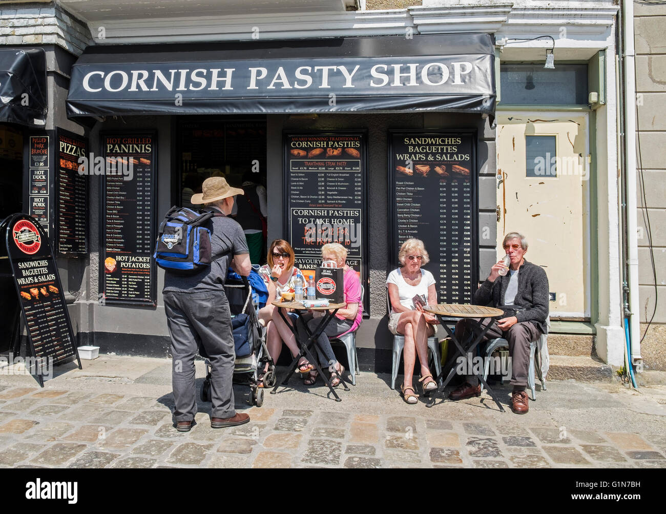 Clients assis à l'extérieur d'un Pasty shop à St.Ives, Cornwall, England, UK Banque D'Images