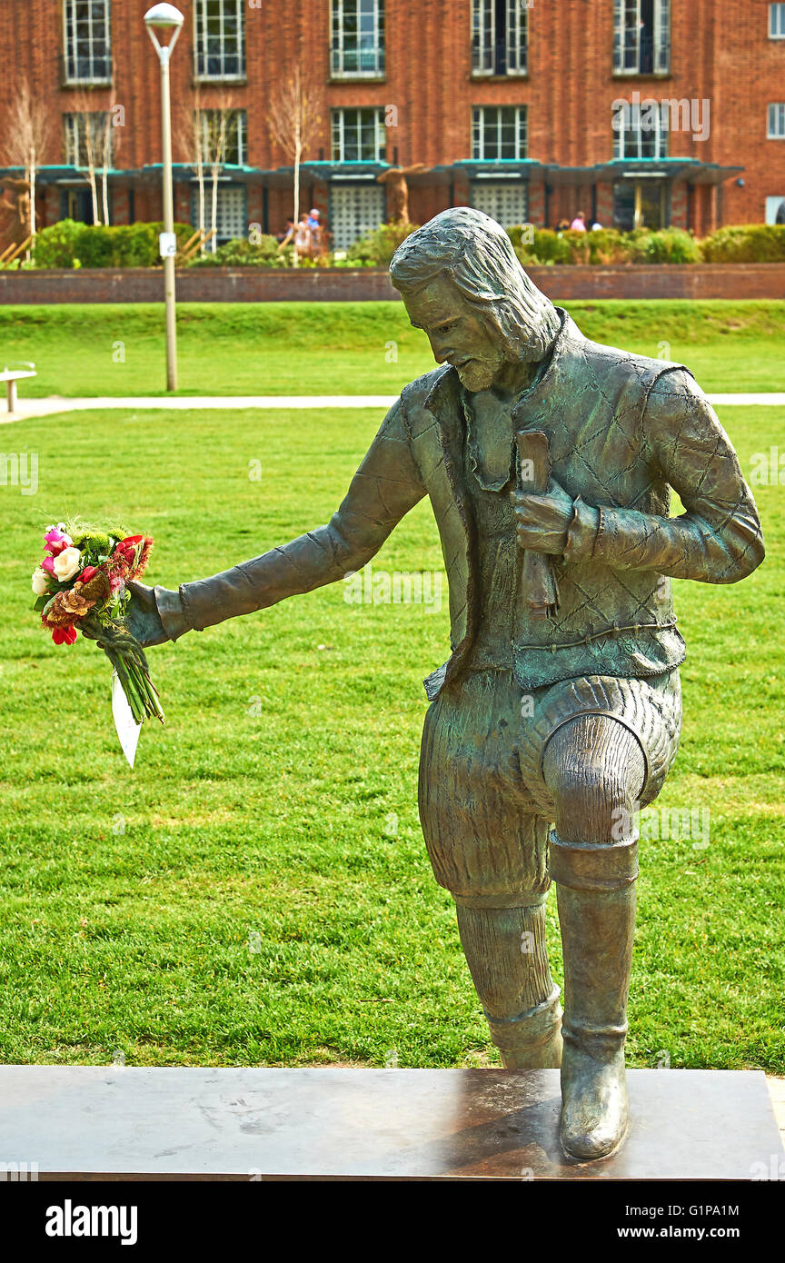 Statue de William Shakespeare dans les jardins de Bancroft, Stratford upon Avon tenant un bouquet de fleurs. Banque D'Images