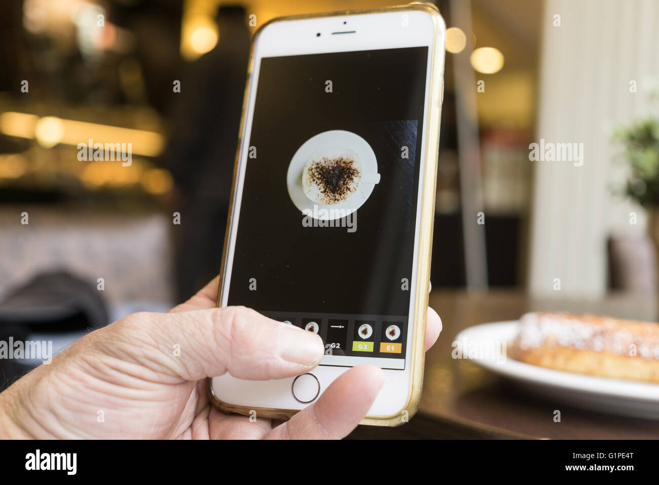BERLIN, ALLEMAGNE - 17 MAI 2016 : l'édition de l'homme son mobile photo d'une tasse de café avec l'iPhone et VSCO Cam app. Banque D'Images