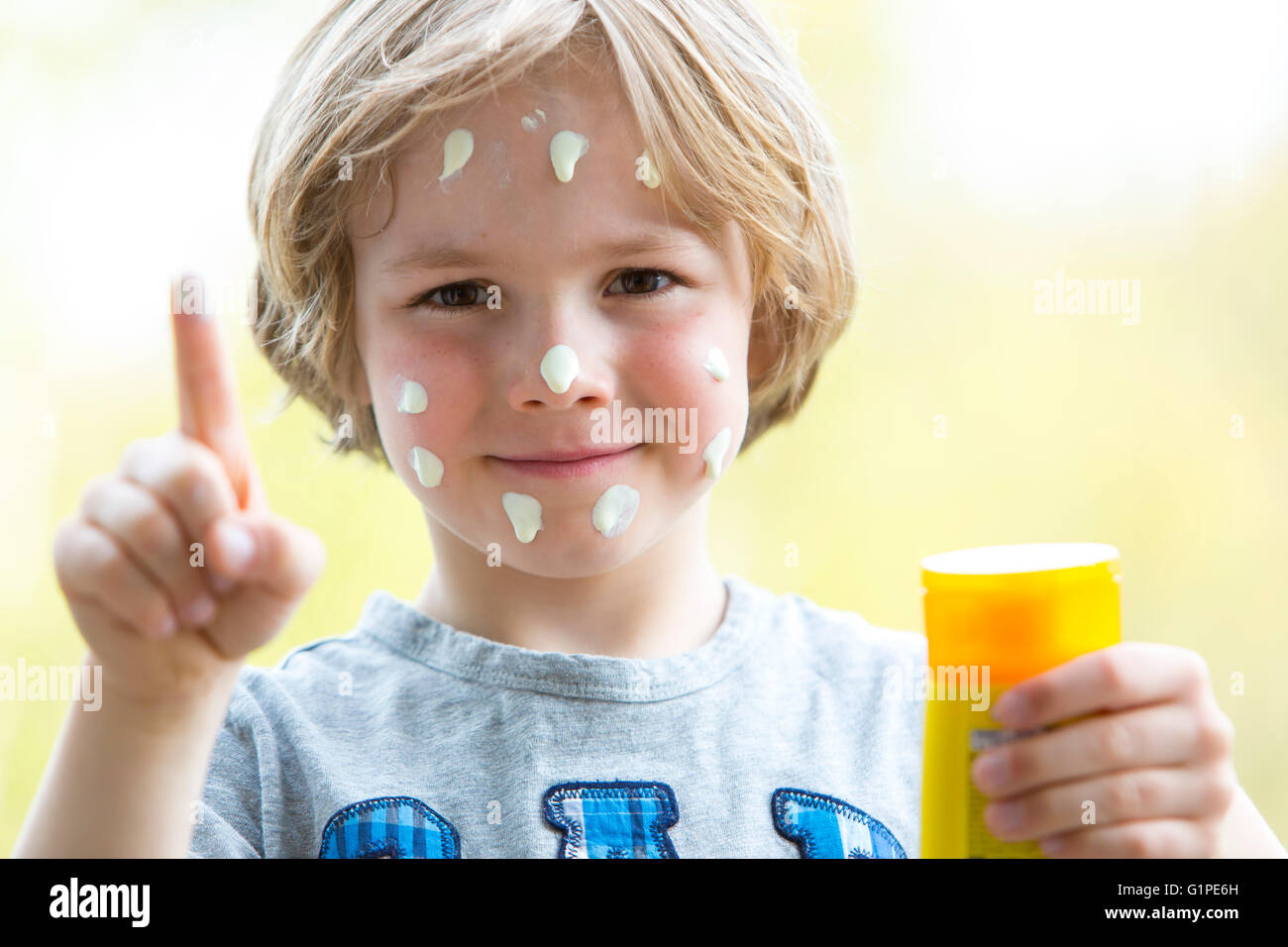 Petit garçon se met de la crème solaire sur le visage, la protection contre le soleil, Banque D'Images