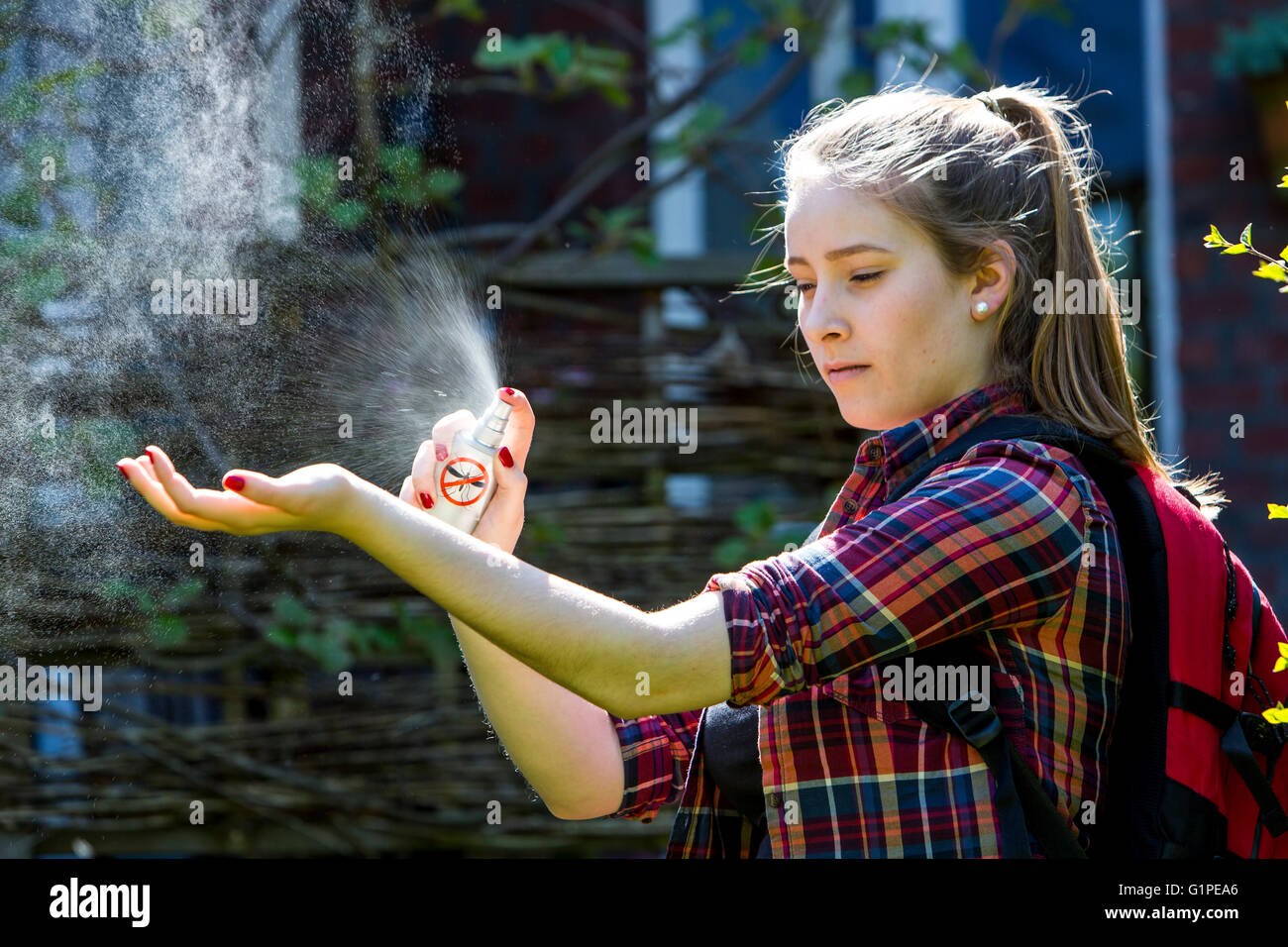 L'insectifuge, jeune femme utilise un spray anti-moustiques, avant une randonnée, en le vaporisant sur le la peau, Banque D'Images