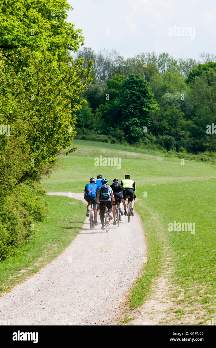Les cyclistes dans les North Downs Way et passage à niveau du chemin de Colley colline au-dessus de Reigate. Voyageant à l'Est. Banque D'Images