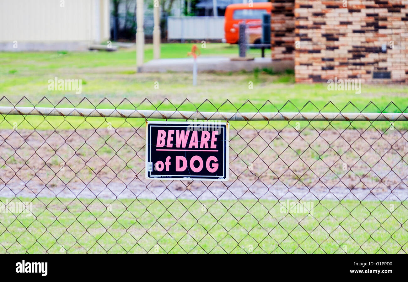 Attention au chien sign sur une clôture cyclone autour d'une maison en Arizona, USA. Banque D'Images