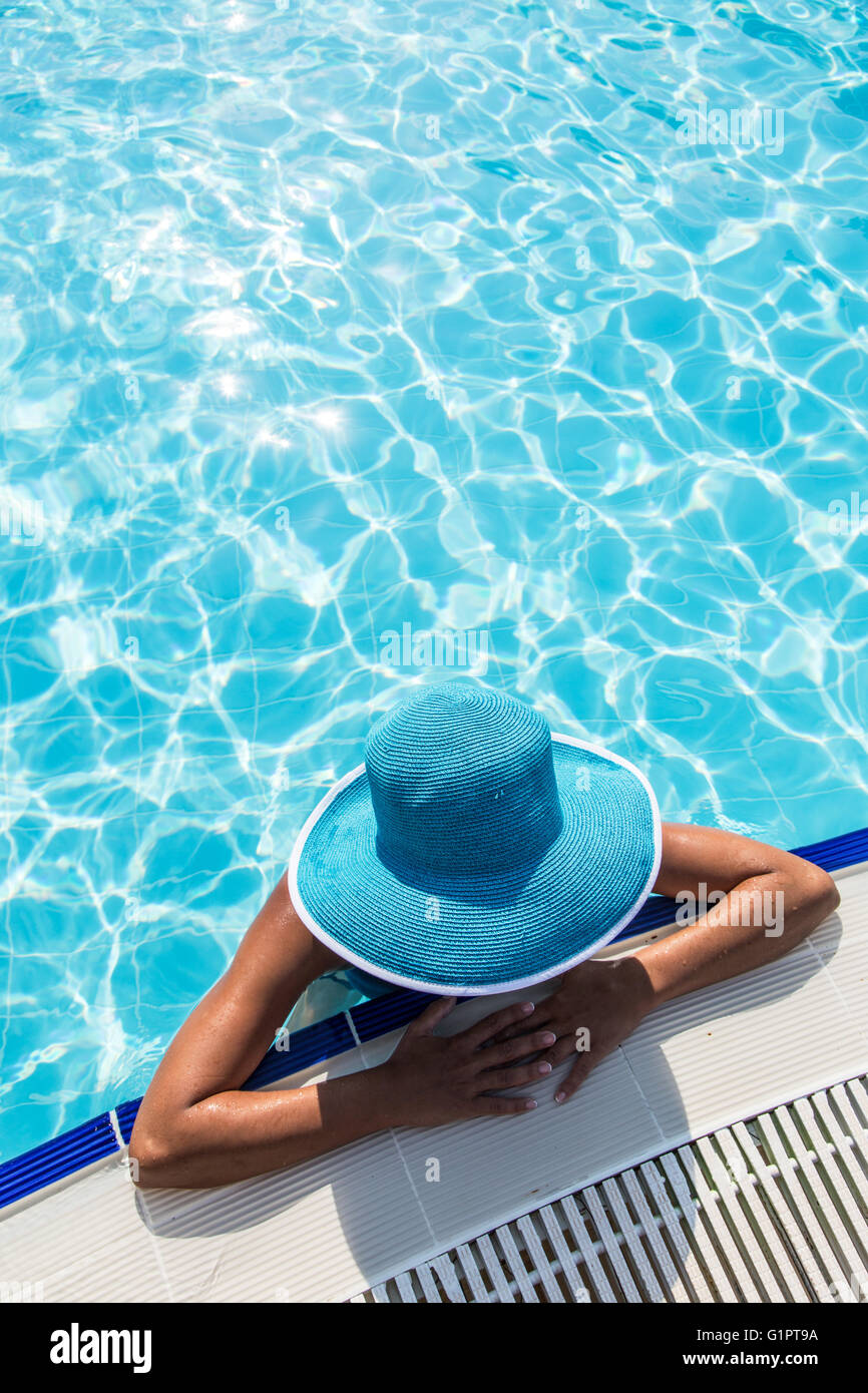 Femme au chapeau de soleil dans la piscine. Vue d'en haut. Banque D'Images