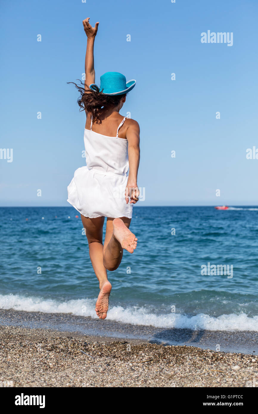 Femme sautant sur la plage. Banque D'Images