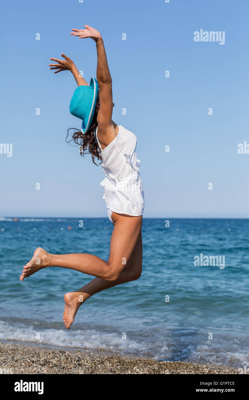 Femme sautant sur la plage. Banque D'Images