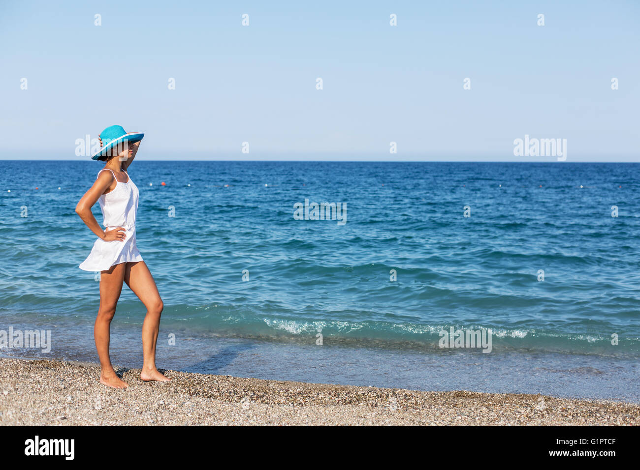 La femme est sur la plage près du bord de l'eau. Banque D'Images