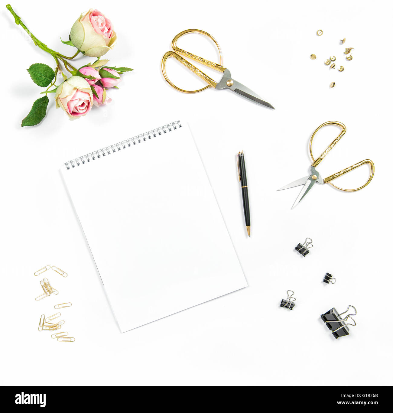 Mise à plat avec sketchbook, fleurs, outils office sur fond blanc Banque D'Images
