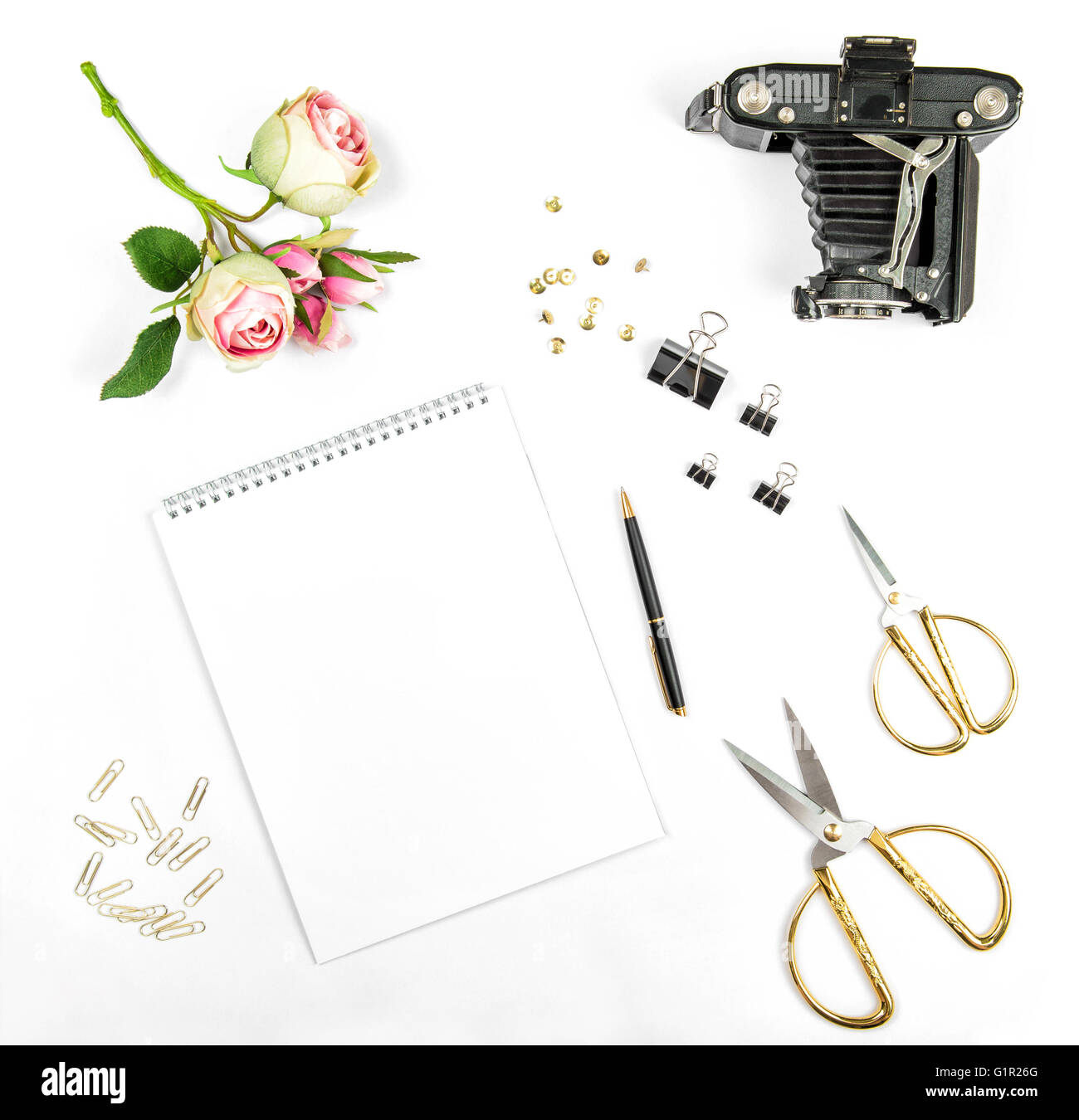 Mise à plat avec sketchbook, fleurs, vintage photo, caméra outils office sur fond blanc Banque D'Images