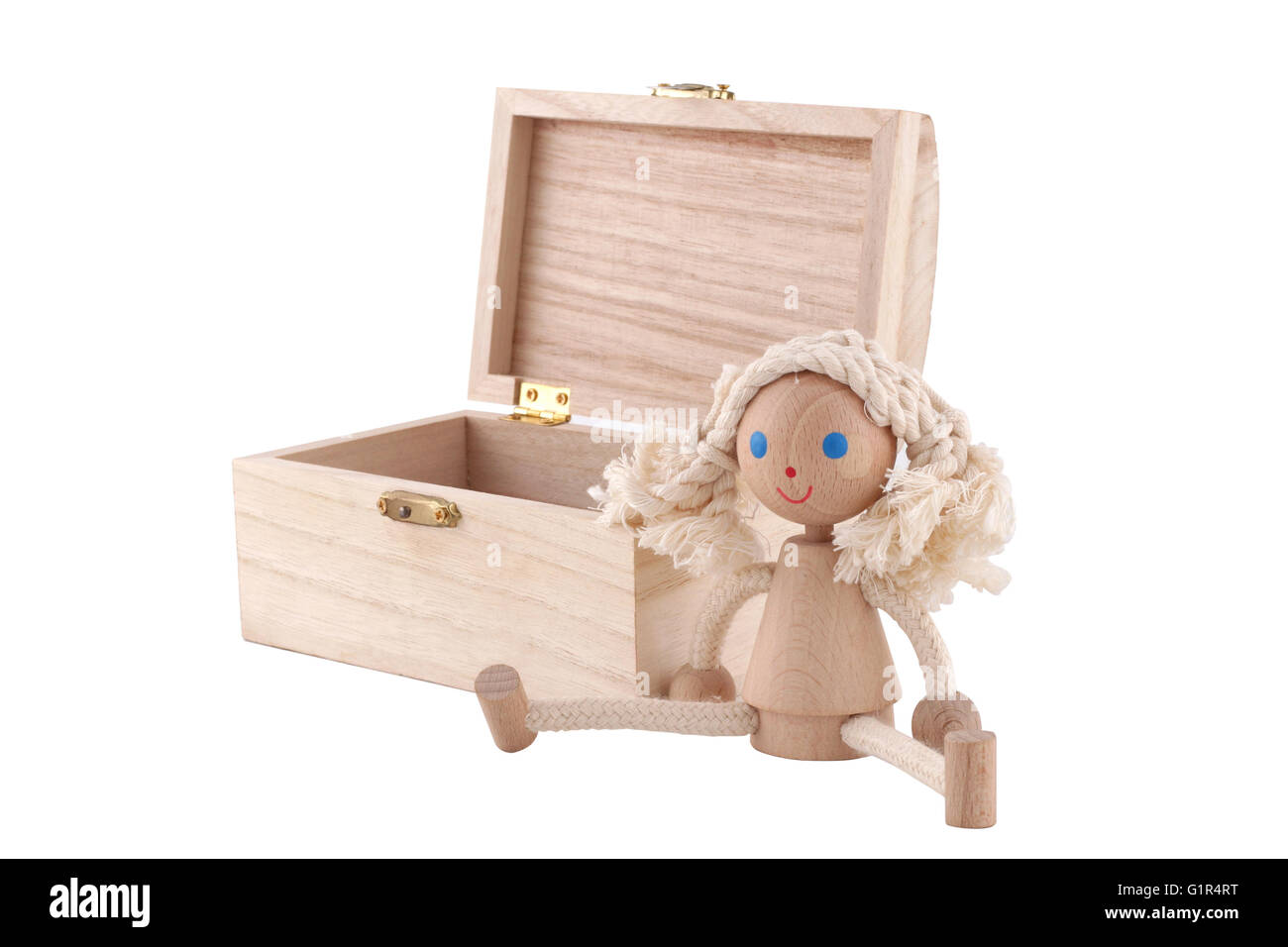 L'horizontale vue frontale d'une poupée jouet en bois à proximité d'une poitrine sur fond blanc Banque D'Images