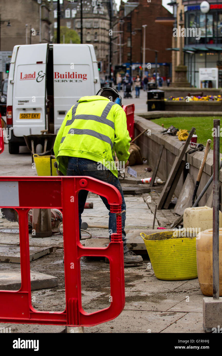 Ouvriers de la société d'ingénierie civile "Terre & Building Services" la coupe et la pose des dalles de béton dans la région de Dundee, Royaume-Uni Banque D'Images