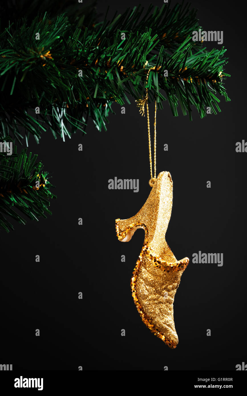 Chaussure d'or sur l'arbre de Noël artificiel Banque D'Images