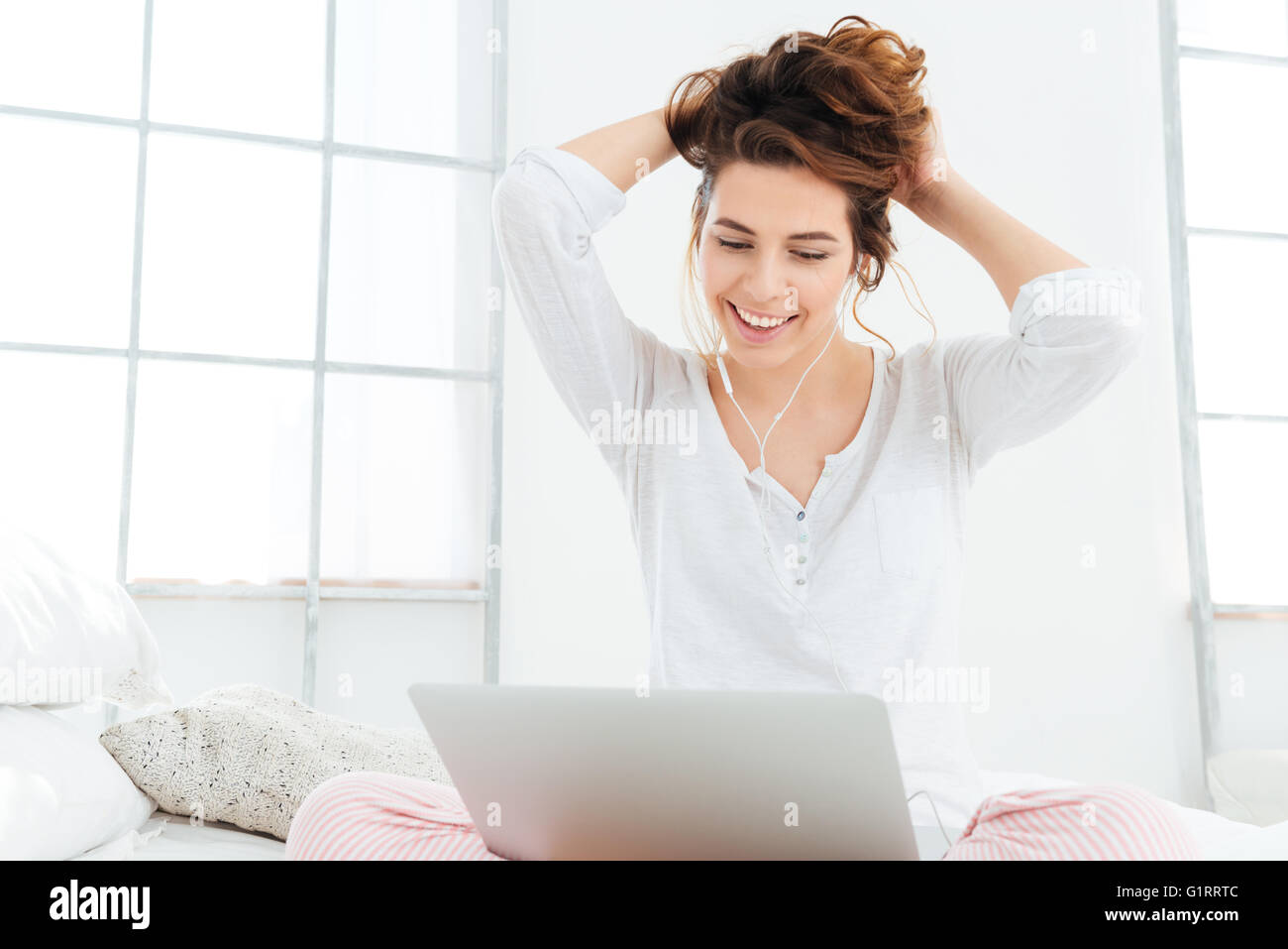 Smiling woman sur le lit à la maison Banque D'Images