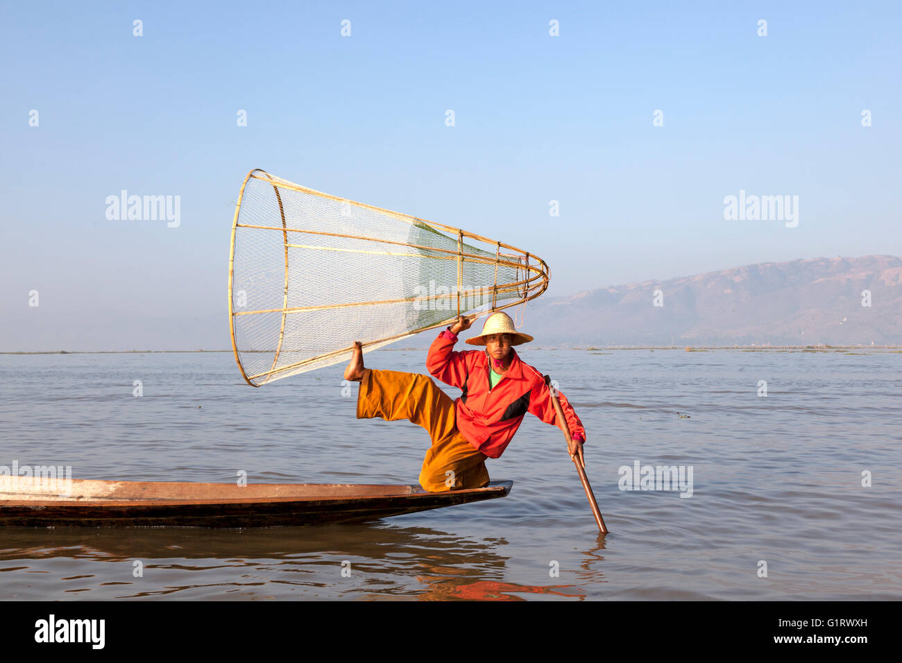 Sur le lac Inle, un pêcheur de son piège poissons sur un mouvement acrobatique (Myanmar). Pêcheur à la nasse sur le lac Inlé. Banque D'Images