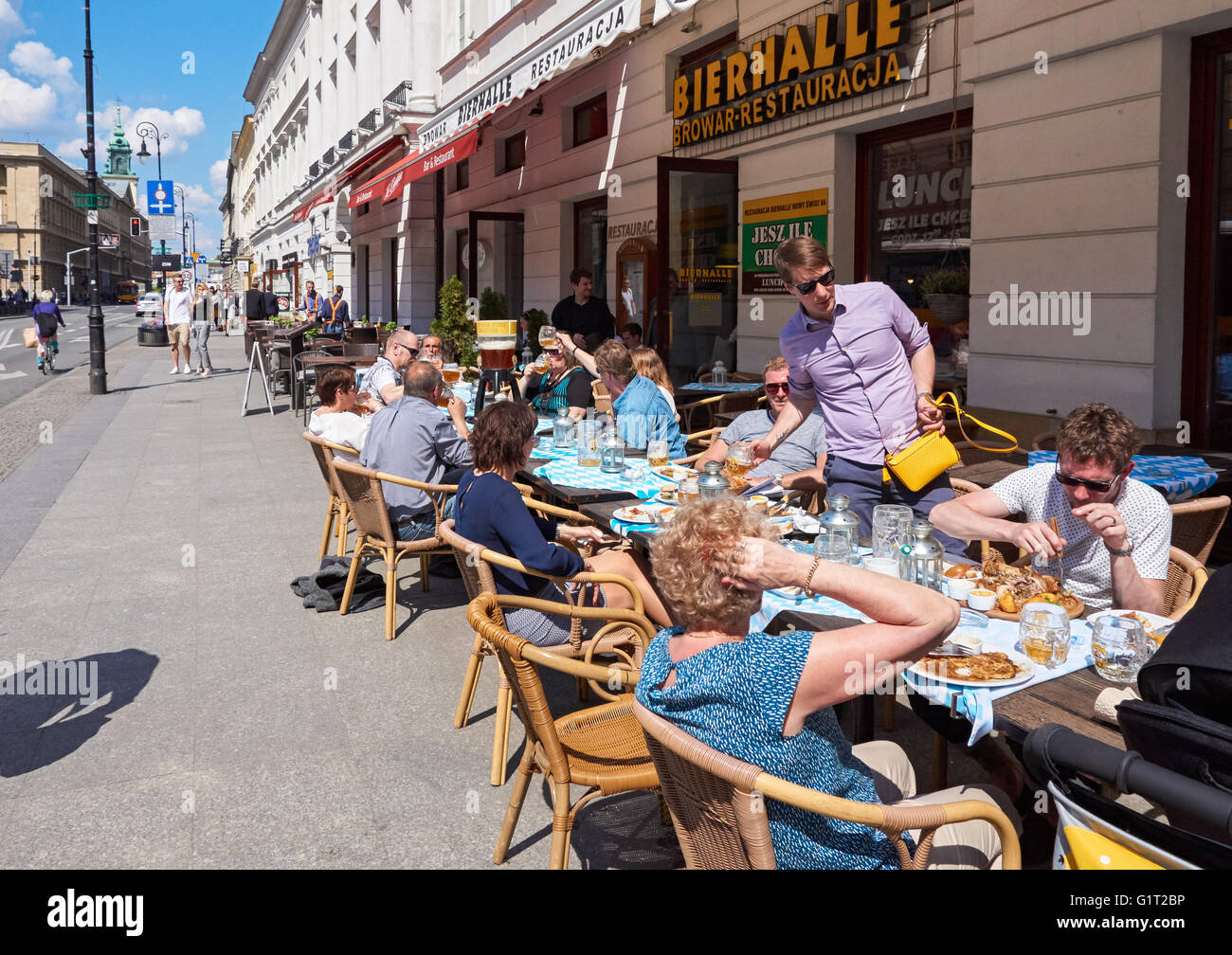 Les gens assis à l'extérieur restaurant sur la rue Nowy Swiat à Varsovie, Pologne Banque D'Images
