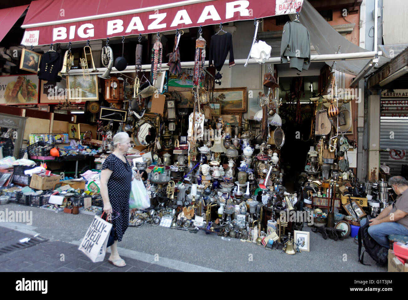 Une femme passe devant le big bazar boutique, dans le centre d'athènes , Grèce, la vente de bric-à-brac, d'antiquités et d'ordure Banque D'Images