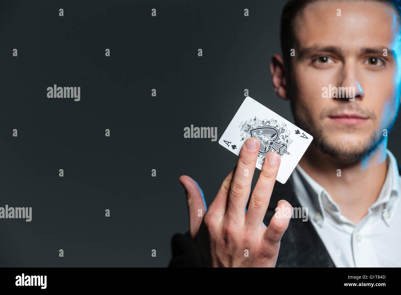 Portrait du jeune magicien holding as sur fond gris Banque D'Images