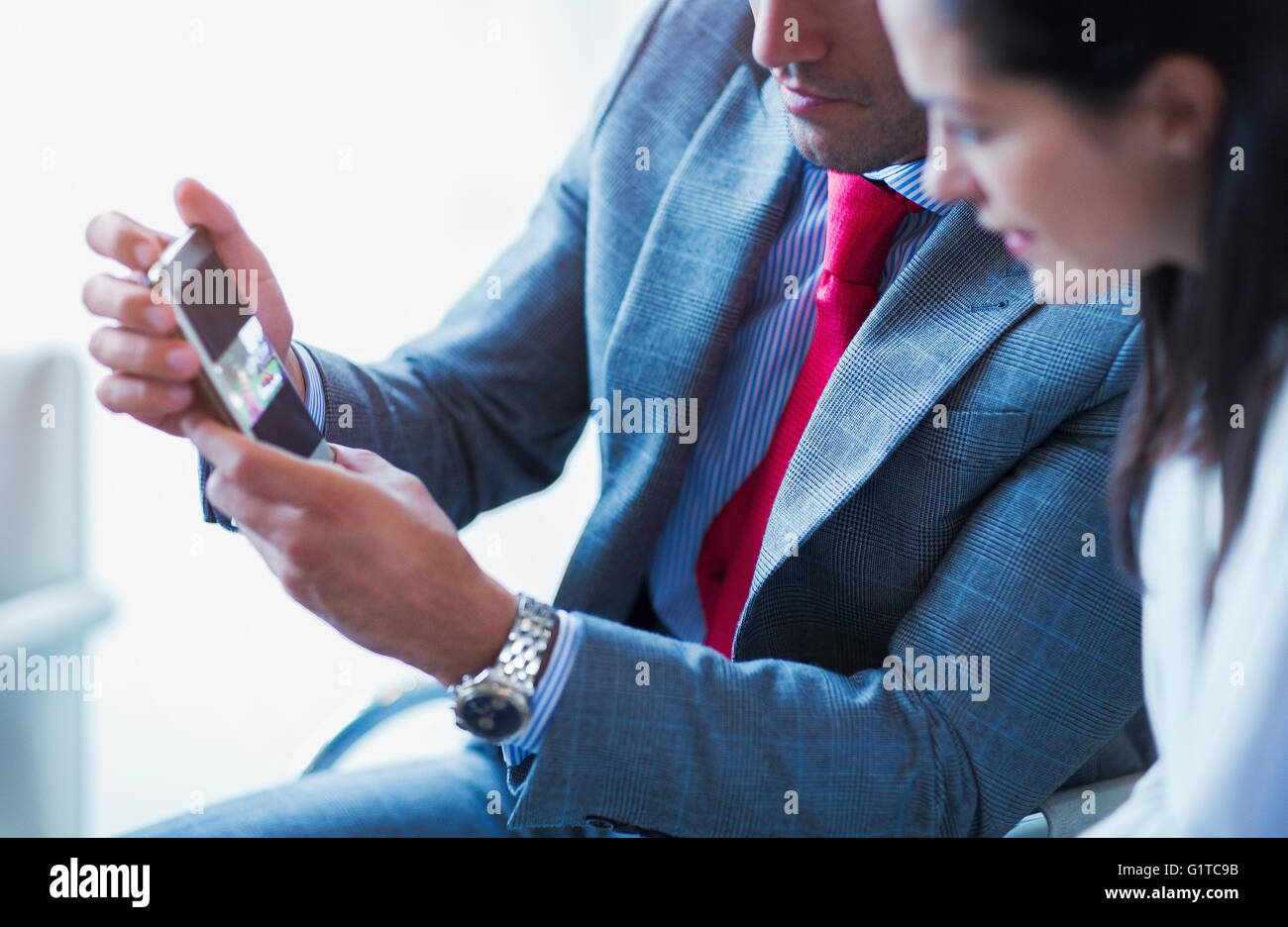 Businessman showing cell phone vidéo pour businesswoman Banque D'Images