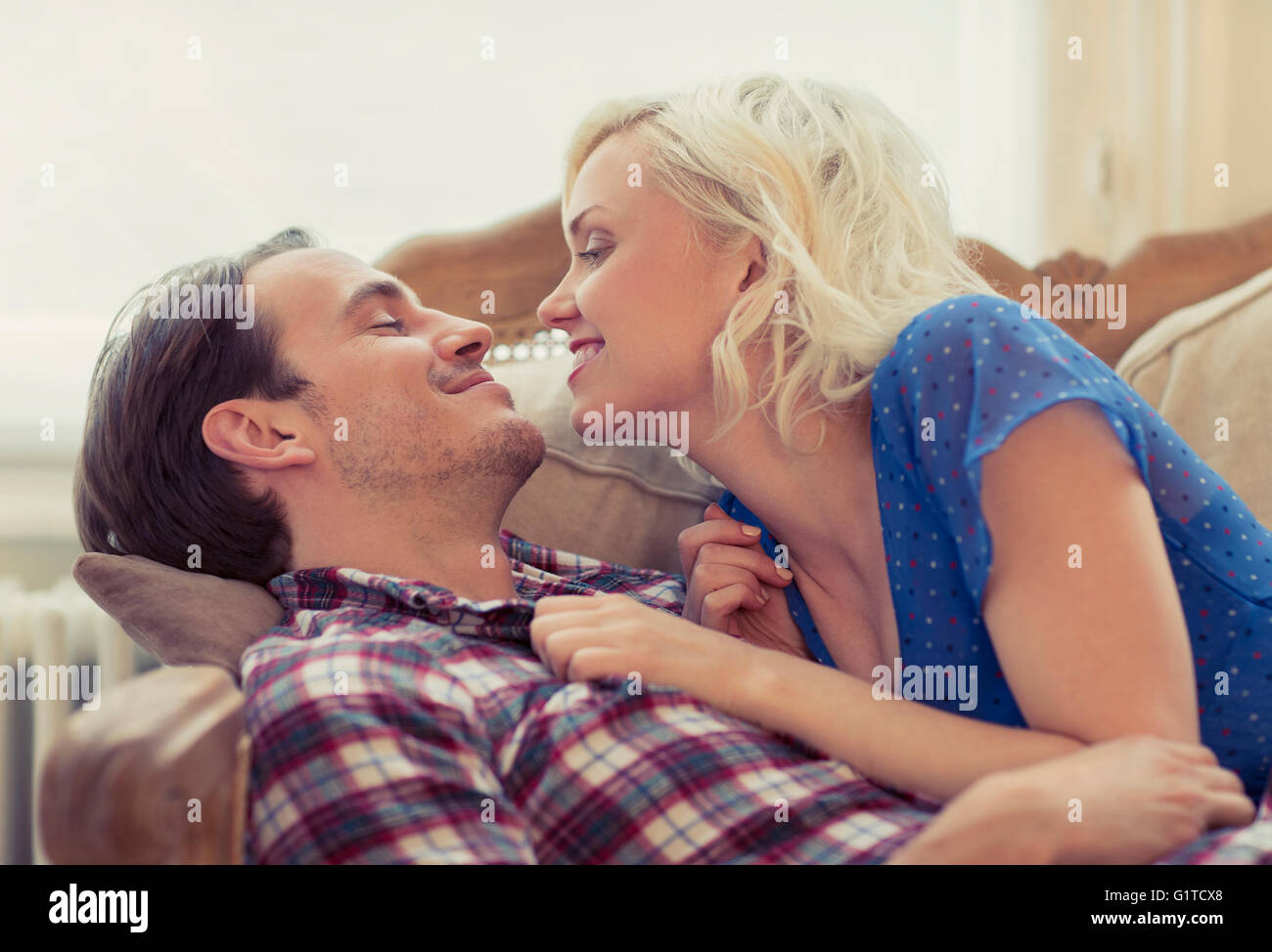 Affectionate couple laying on sofa Banque D'Images