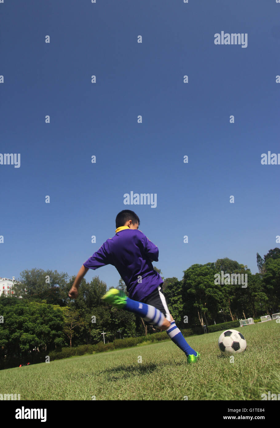 Un garçon jouer football buteur haute puissance shoot shoot kick Banque D'Images