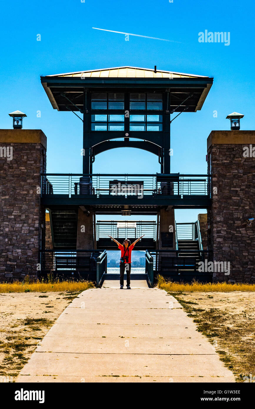 Une femme heureuse avec bras levés au milieu parc littoral Port au Port d'Oakland Banque D'Images