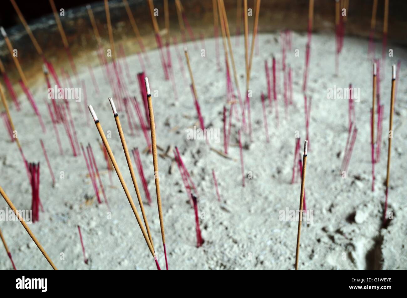 Bâtons d'encens plantés dans le sable à l'entrée d'un temple bouddhiste Banque D'Images