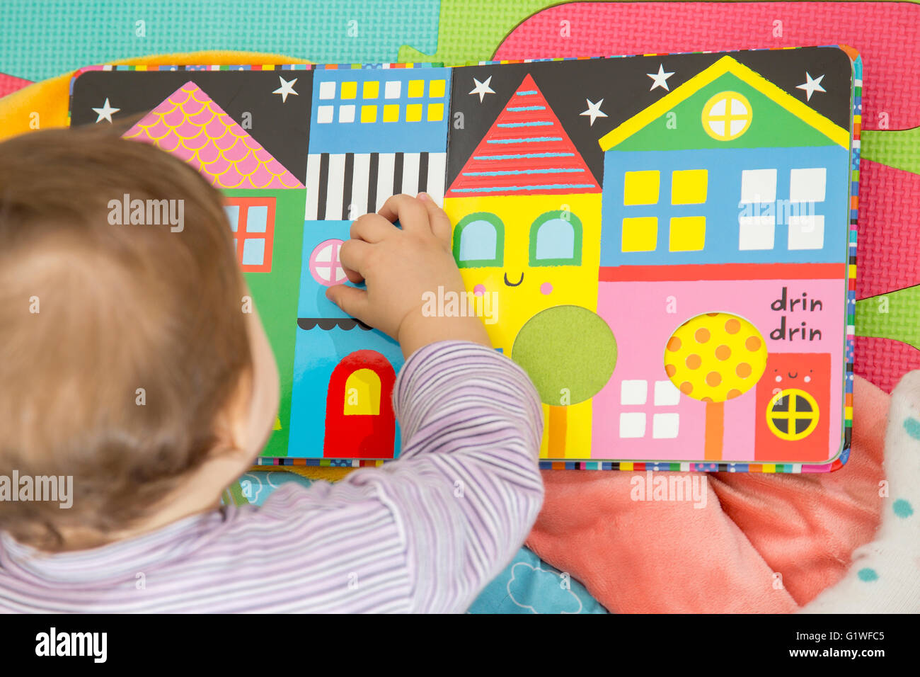 Méconnaissable d'un an avec enfant livre coloré Banque D'Images