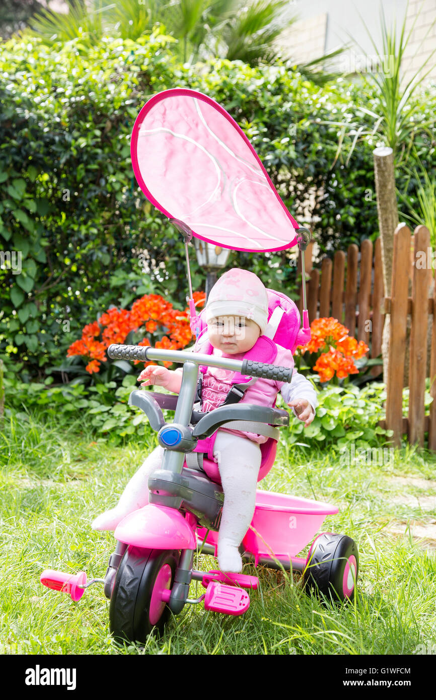 Portrait de l'adorable petite fille de 6 mois sur rose location in garden Banque D'Images