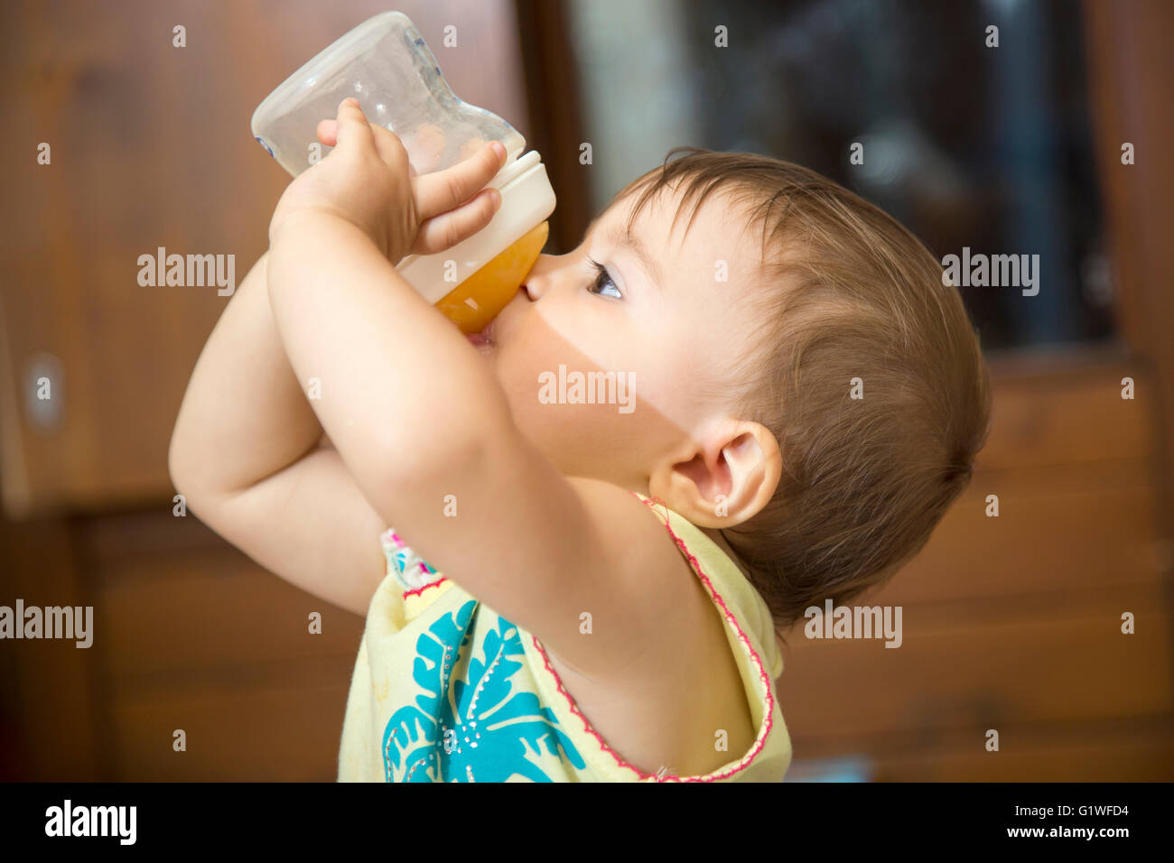Vue latérale d'un an à partir de l'eau potable baby girl feeding bottle Banque D'Images