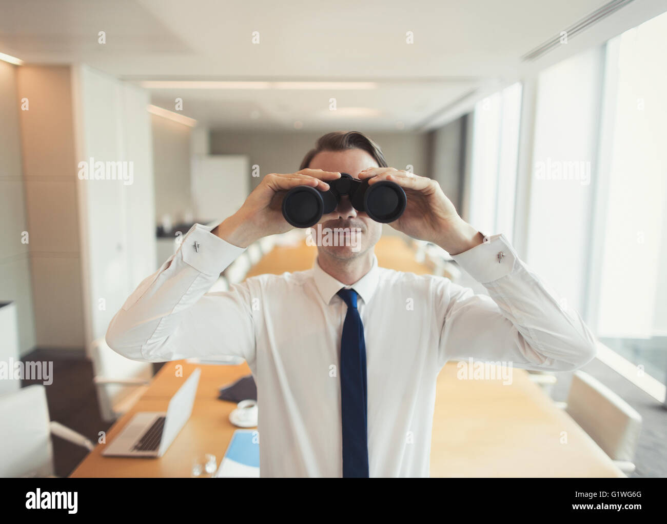 Portrait of businessman à l'aide de jumelles dans la salle de conférence Banque D'Images