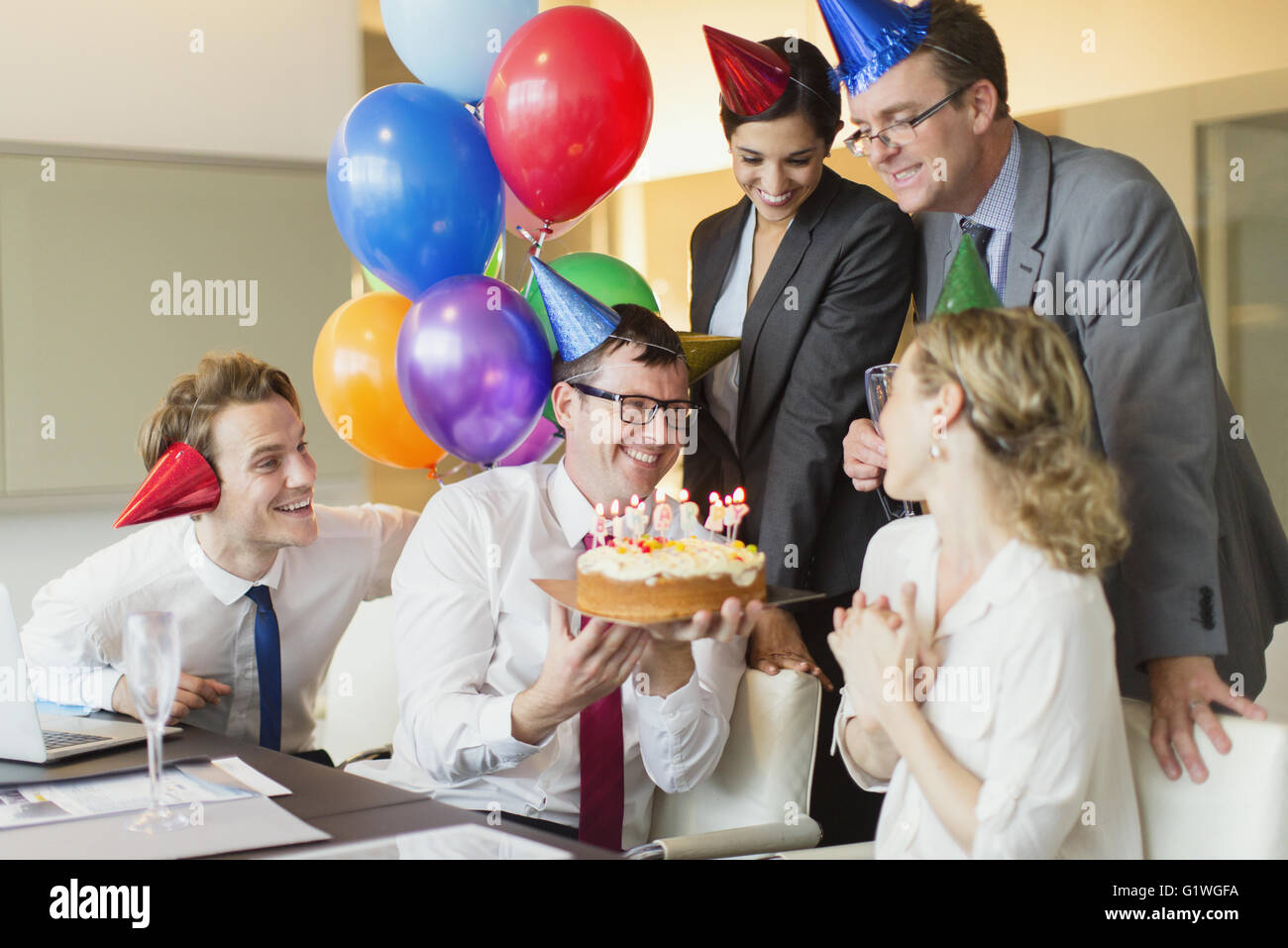 Collègues présentant businesswoman avec gâteau d'anniversaire dans la salle de conférence Banque D'Images