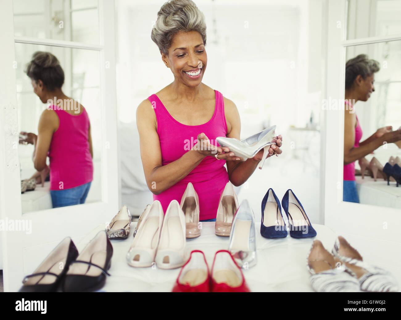 Smiling mature woman looking at High heels dans la penderie Banque D'Images