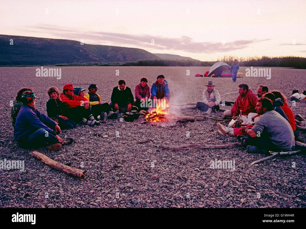 Les voyageurs d'aventure américaine avec guides soviétique s'asseoir autour d'un feu de camp, Belaya River, Magadon Région, Sibérie, frmr Union Soviétique Banque D'Images